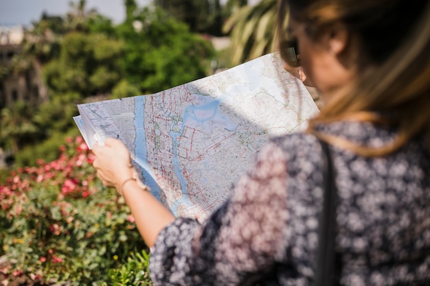 Foto gratuita primer plano de mujer buscando la dirección correcta en el mapa