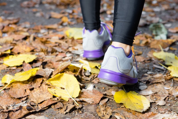 Primer plano de mujer caminando con zapatillas de deporte