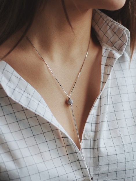 Foto gratuita primer plano de una mujer con una camisa blanca y un delicado collar de plata