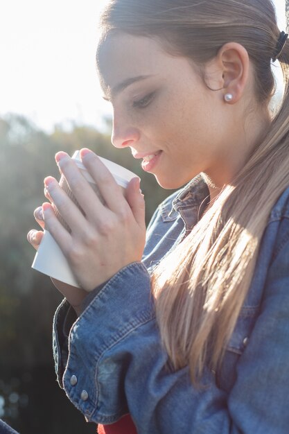 Primer plano de mujer con coleta y un café