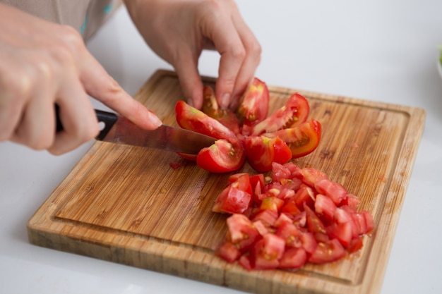 Primer plano, mujer, corte, tomates, cuchillo