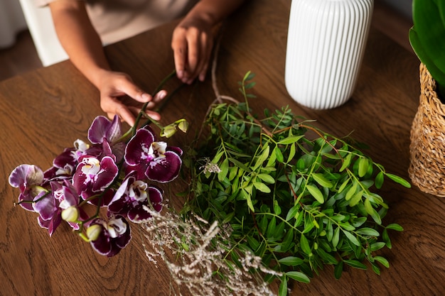 Primer plano de una mujer decorando su casa con orquídeas