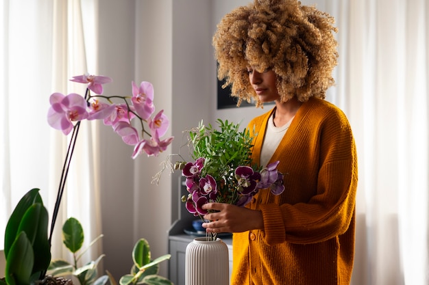 Primer plano de una mujer decorando su casa con orquídeas
