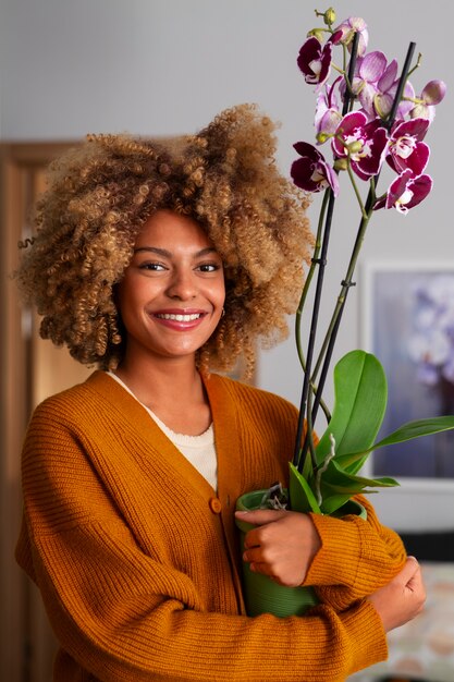 Primer plano de una mujer decorando su casa con orquídeas