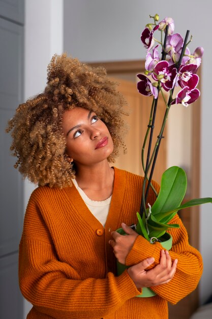 Foto gratuita primer plano de una mujer decorando su casa con orquídeas