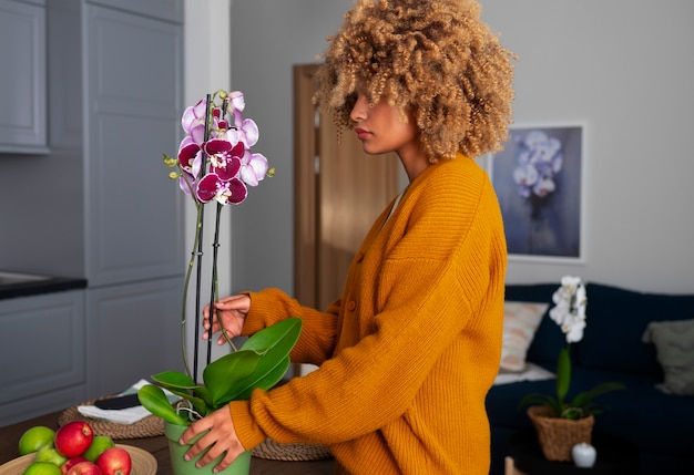 Primer plano de una mujer decorando su casa con orquídeas