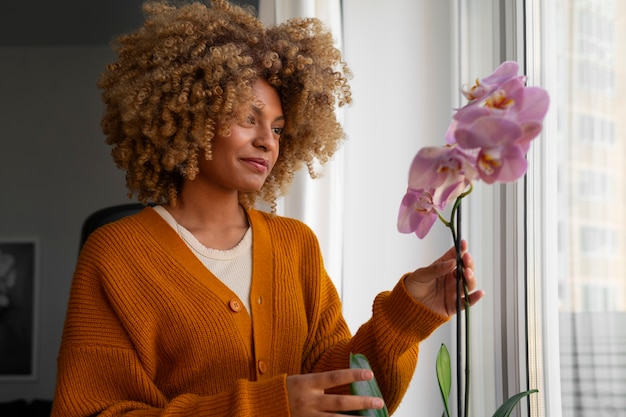 Primer plano de una mujer decorando su casa con orquídeas