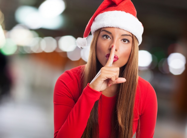 Primer plano de mujer con un dedo sobre sus labios