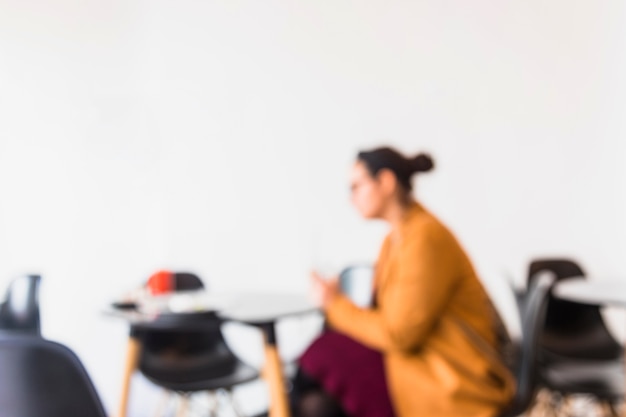 Primer plano de mujer desenfoque sentado en la cafetería