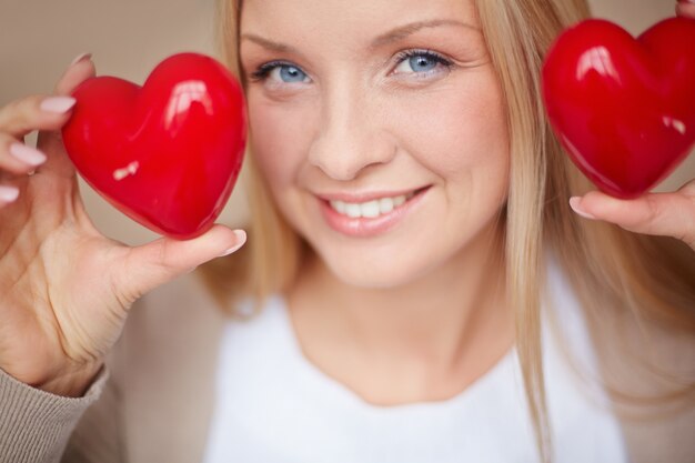 Foto gratuita primer plano de mujer con dos corazones rojos