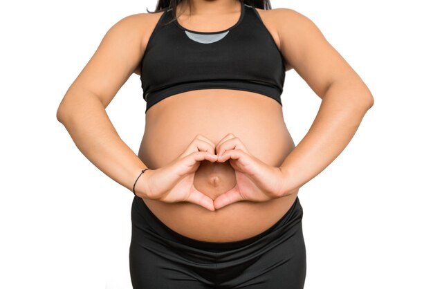 Primer plano, de, mujer embarazada, hacer, forma corazón, con, manos, vientre