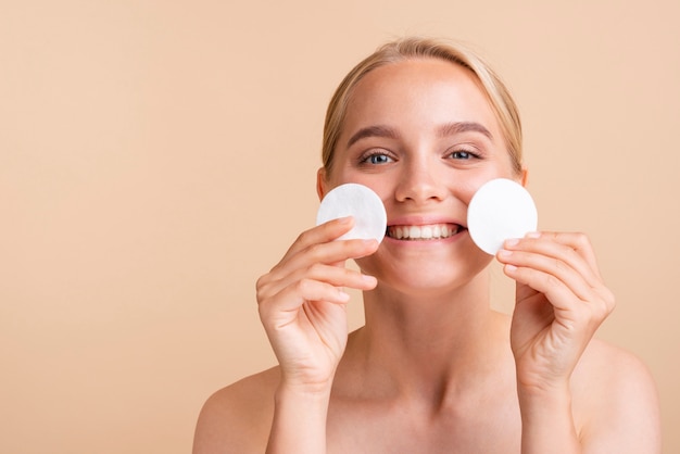 Primer plano mujer feliz con almohadillas de algodón