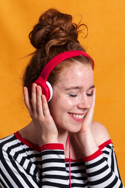 Primer plano mujer feliz escuchando música con auriculares