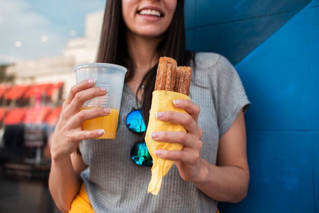 Primer plano mujer feliz con jugo de naranja