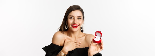 El primer plano de una mujer feliz mostrando su anillo de compromiso recibe una propuesta de matrimonio diciendo que sí de pie