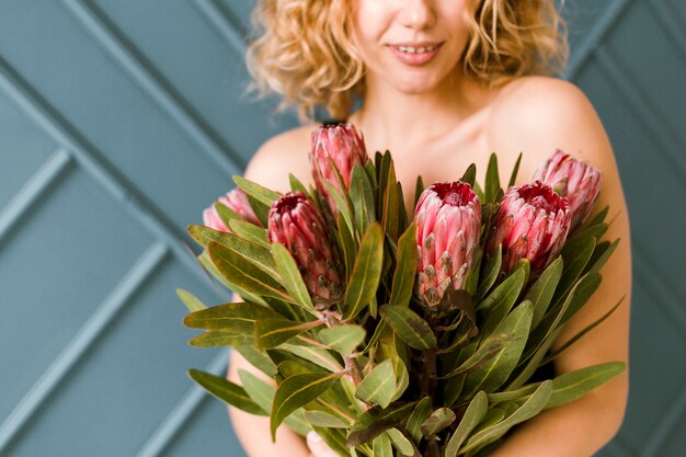 Primer plano mujer feliz con ramo de flores en el interior