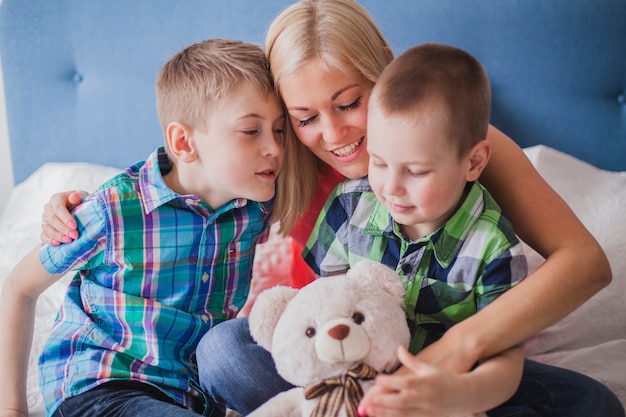 Foto gratuita primer plano de mujer feliz con sus hijos y un oso de peluche