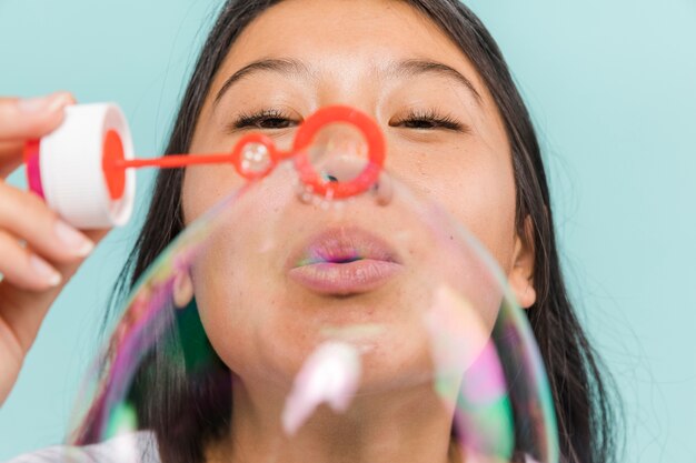 Primer plano de mujer haciendo burbujas