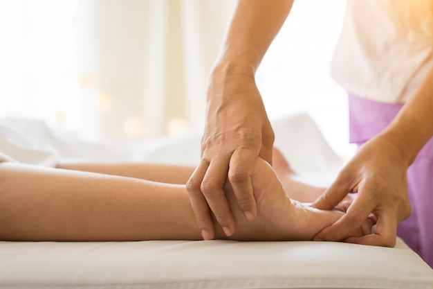 Primer plano de mujer haciendo masaje de pies en el spa.