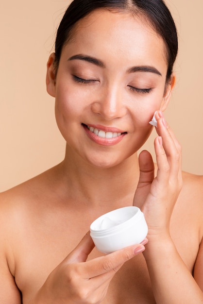 Primer plano mujer hermosa con crema para la cara