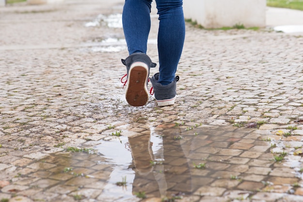 Primer plano de mujer irreconocible caminando en el camino de piedra