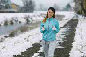 Foto gratuita primer plano de mujer jogger jogging en paisaje nevado