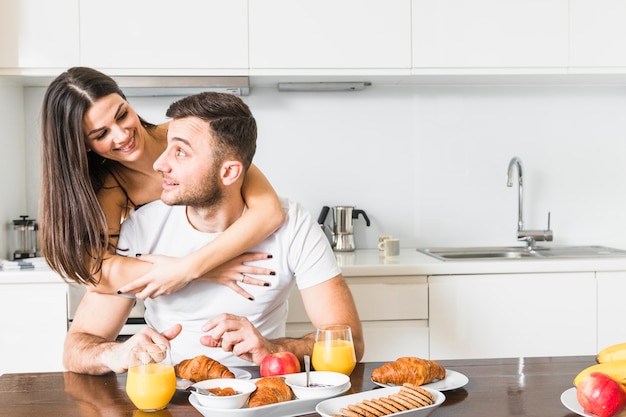 Primer plano de mujer joven abrazando a su novio desayunando