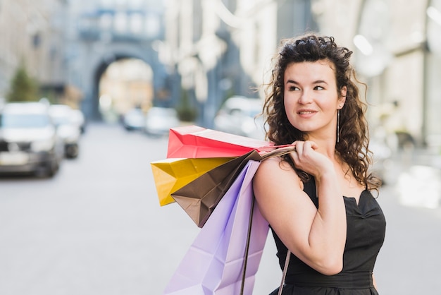 Primer plano de una mujer joven con bolsas de papel de colores