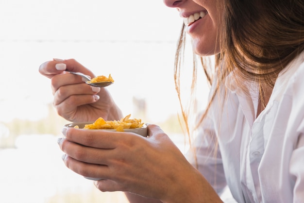 Primer plano, de, mujer joven, comer, cornflakes, con, cuchara