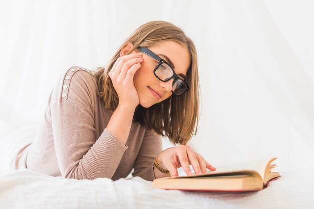 Primer plano de mujer joven disfrutando de libro de lectura