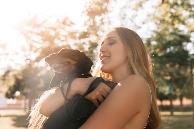 Primer plano de una mujer joven disfrutando con su perro en el parque