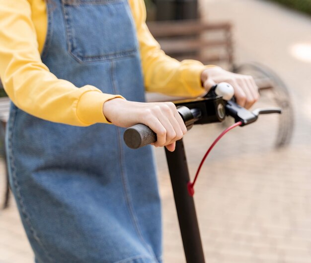 Primer plano, mujer joven, equitación, scooter