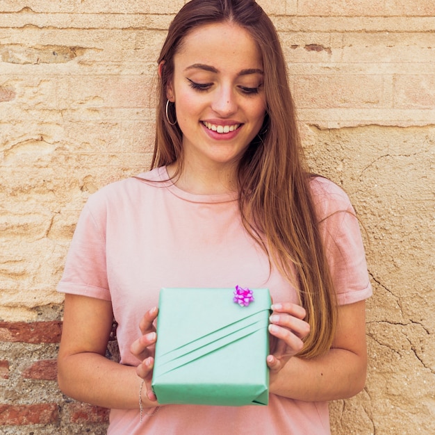 Primer plano de una mujer joven feliz con caja de regalo verde