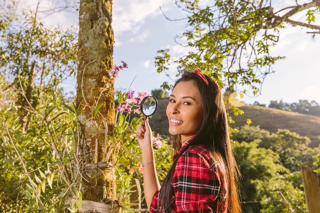 Primer plano de una mujer joven feliz con lupa