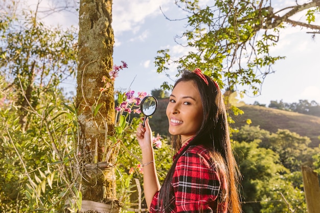 Primer plano de una mujer joven feliz con lupa