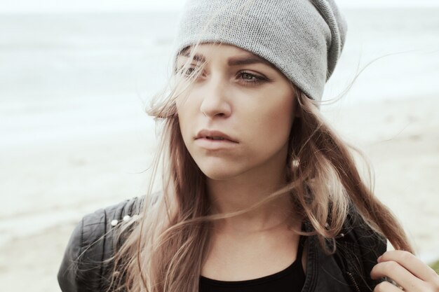 Primer plano de mujer joven con gorro gris