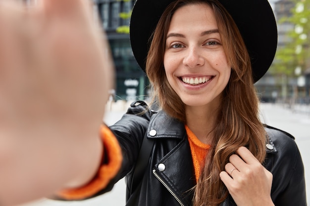 Foto gratuita primer plano de una mujer joven optimista tiene la mano extendida