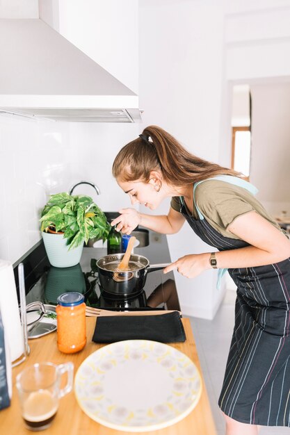 Primer plano, de, mujer joven, prueba, sopa, en, cacerola