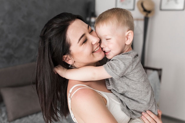 Primer plano de mujer joven sonriente amar a su hijo