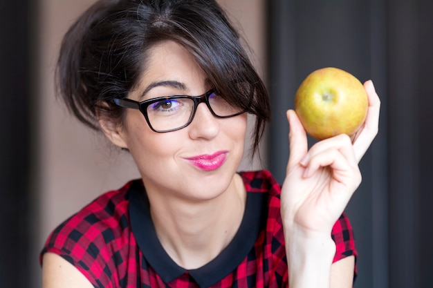 Primer plano de mujer joven sonriente con una manzana