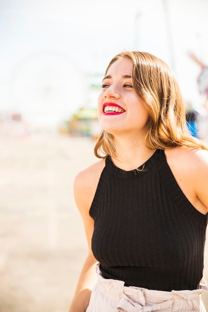 Primer plano de mujer joven sonriente en el parque de atracciones