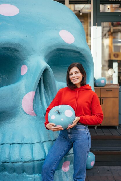 Primer plano de una mujer joven sosteniendo una calabaza ornamentada