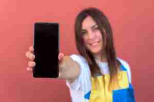 Foto gratuita primer plano de una mujer joven con su smartphone posando en la cámara