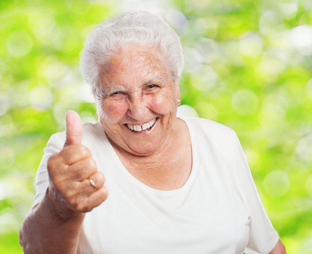 Primer plano de mujer jubilada con el pulgar hacia arriba