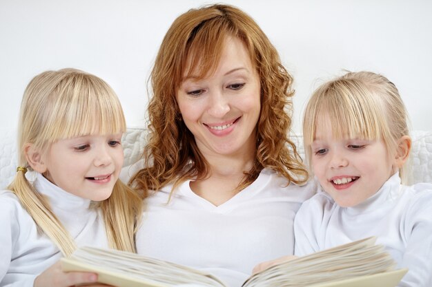 Primer plano de mujer leyendo con sus hijas