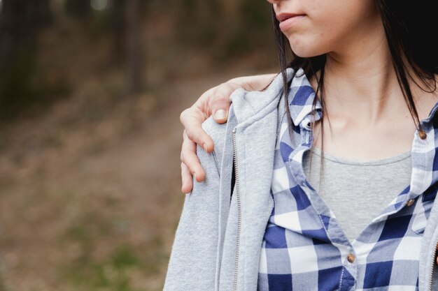 Primer plano de mujer con una mano en su hombro