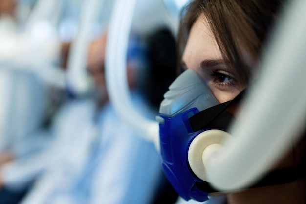 Primer plano de una mujer con mascarilla durante la oxigenoterapia hiperbárica en la clínica