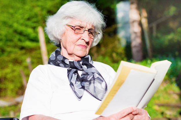 Primer plano de mujer mayor leyendo una novela