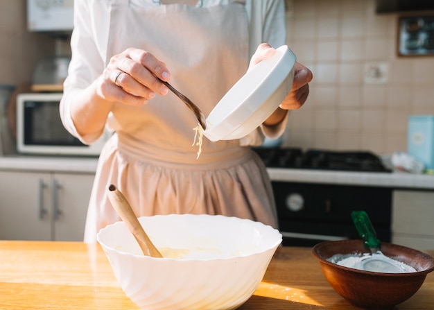 Primer plano de una mujer mezclando ingredientes para preparar pastel