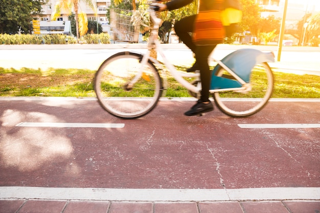 Primer plano de una mujer montando la bicicleta en el parque